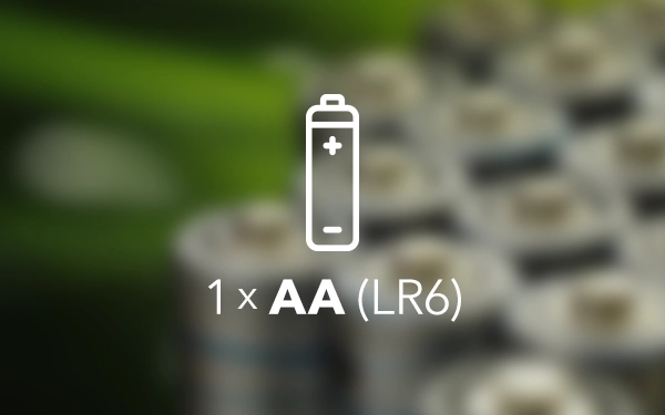 Значок батарейки з текстом 1×AA (LR6) на тлі розмитих елементів батарейки у відтінках зеленого та сірого.