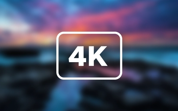 Иконка со словом 4K в рамке на размытом фоне пейзажа с закатом над морем.