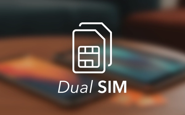 Символ двох SIM-карток білого кольору на розмитому фоні смартфонів, що лежать на столі.