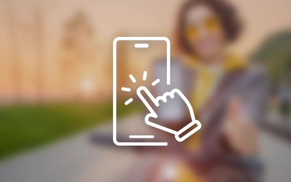 Значок смартфона с рукой, касающейся экрана, на размытом фоне человека в желтых очках и толстовке.