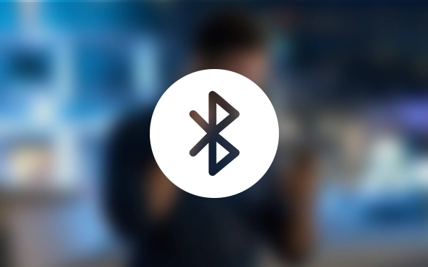 Значок Bluetooth (беспроводное соединение ближнего радиуса действия Bluetooth) на размытом синем фоне.