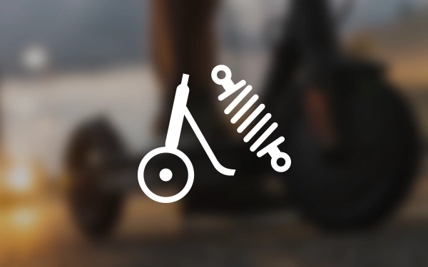 Изображение скутера с символом амортизатора, представляющего собой систему подвески, на размытом фоне, изображающем поездку в сумерках.